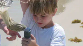 Boy pouring something in a bottle